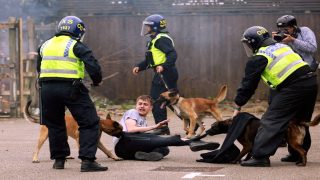 Police dogs attack a man during an anti-immigration protest in Rotherham, Britain, August 4, 2024. REUTERS/Hollie Adams TPX IMAGES OF THE DAY