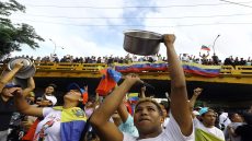 TOPSHOT - A man bangs a cooking pot during a protest against Venezuelan President Nicolas Maduro's government in Valencia, Carabobo state, Venezuela on July 29, 2024, a day after the Venezuelan presidential election. Protests erupted in parts of Caracas Monday against the re-election victory claimed by Venezuelan President Nicolas Maduro but disputed by the opposition and questioned internationally, AFP journalists observed. (Photo by Juan Carlos HERNANDEZ / AFP)